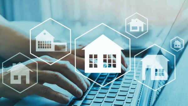 white icons of different types of houses overlayed on hands typing on a keyboard about is my REIN membership deductible?