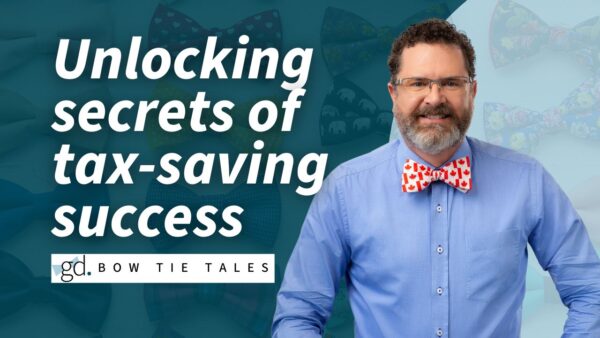 Man in bow tie and blazer, with beard and glasses, on background of bowties
