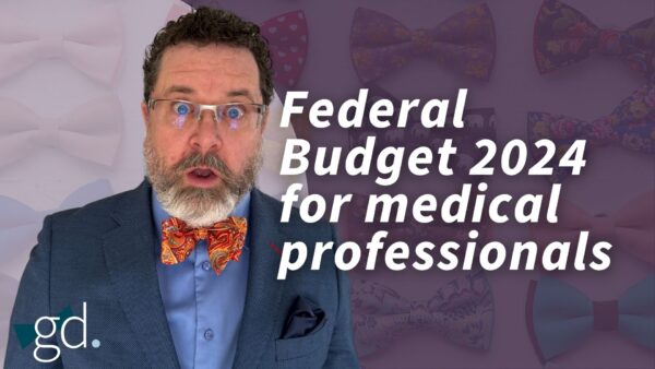 Man in bow tie and suit jacket with glasses grimacing
