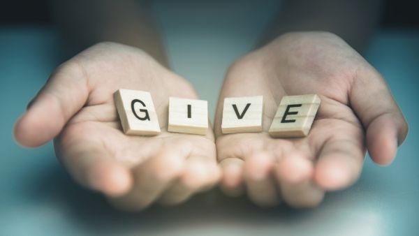 hands holding the letters g i v e to discuss deadline for making charitable donations