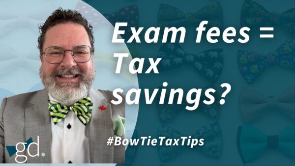 Man in glasses and with a white beard, wearing a light gray suit jacket and green stripy bow tie, talking about tax credit for exam fees