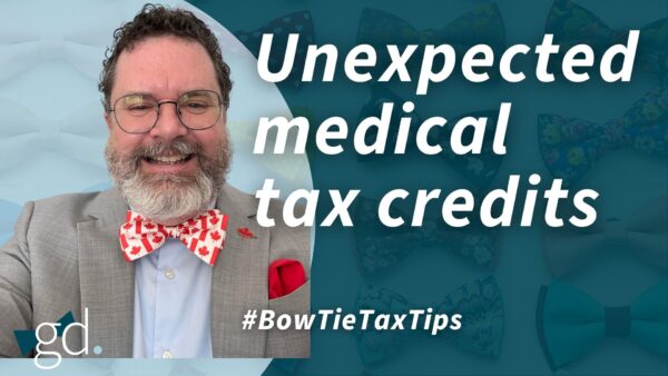 White male with dark, curly hair and a whitish beard and glasses wearing a gray suit jacket with light blue shirt and Canada bow tie, talking about claiming medical expenses